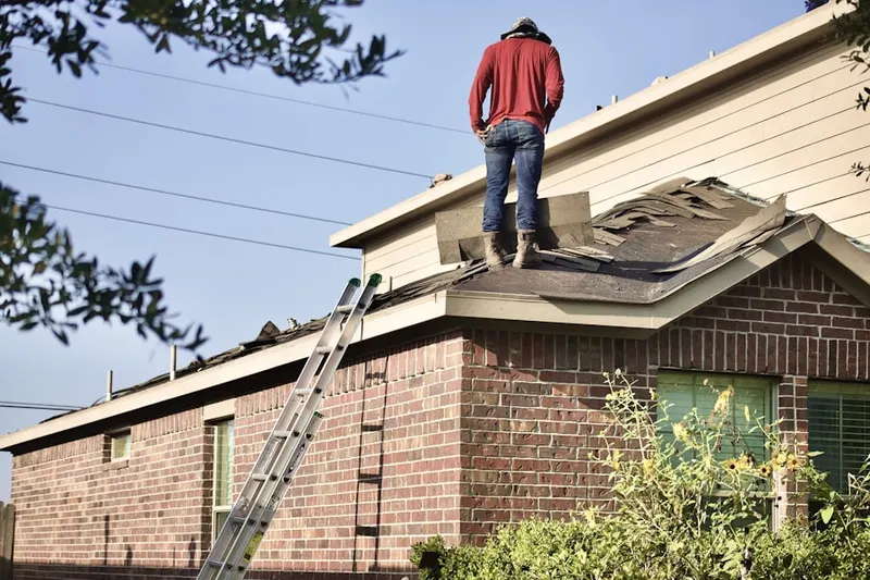 Professional roofer working on a residential roof in Broadway
